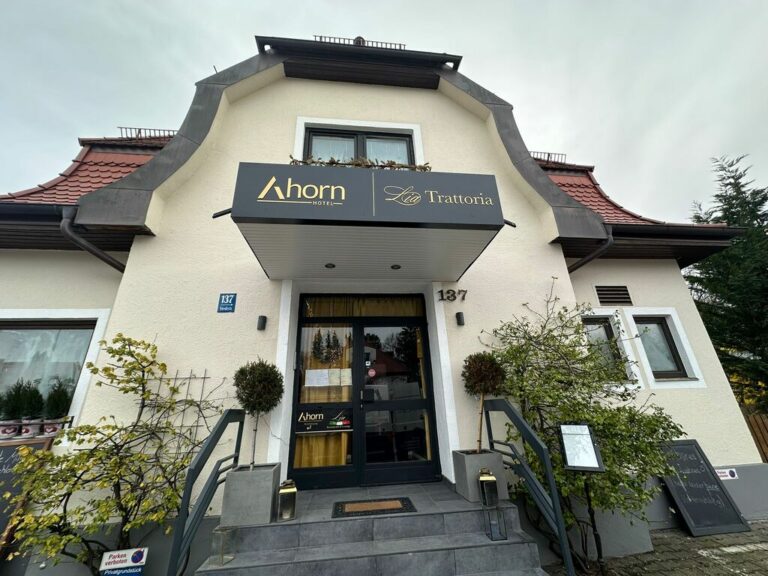 Startseite Fertig montierter Leuchtkasten mit Logo „Ahorn“ und „Trattoria“ über dem Hoteleingang