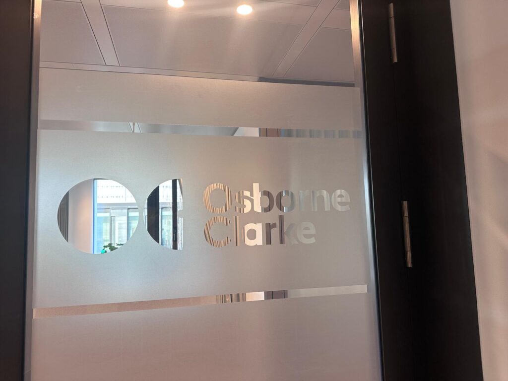 Milchglasfolie auf einer Glastür mit ausgespartem Osborne-Clarke-Logo und zwei transparenten horizontalen Linien